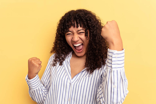 Young mixed race woman isolated on yellow background cheering carefree and excited. Victory concept. - Photo, Image