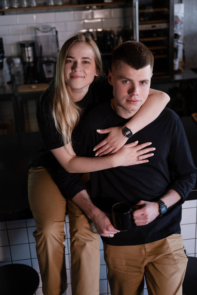 happy married couple in identical clothes family look - cafe owners or workers - in modern coffee shop. family business. loft cafe. - Fotografie, Obrázek