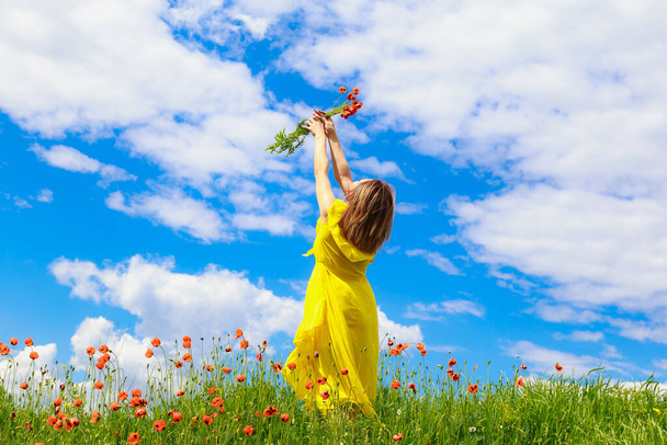 Eine hübsche junge Frau im gelben Kleid genießt einen Spaziergang in der Natur. Glückskonzept - Foto, Bild