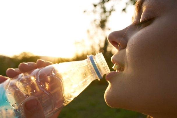 kobieta na zewnątrz woda pitna z butelki orzeźwienia - Zdjęcie, obraz
