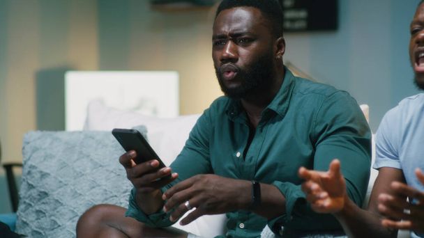 African American fans making bets on smartphones - Fotoğraf, Görsel