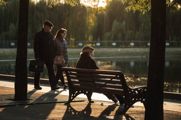 MOSCA, RUSSIA - 06 OTTOBRE 2021: Un uomo seduto su una panchina al tramonto - Foto, immagini