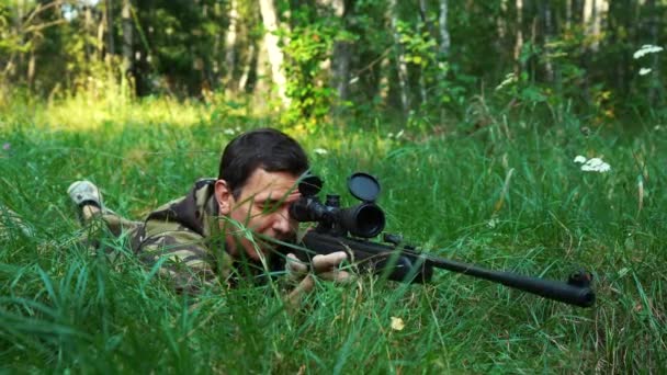 Egy férfi céloz egy mesterlövész puskával a fűben. - Felvétel, videó