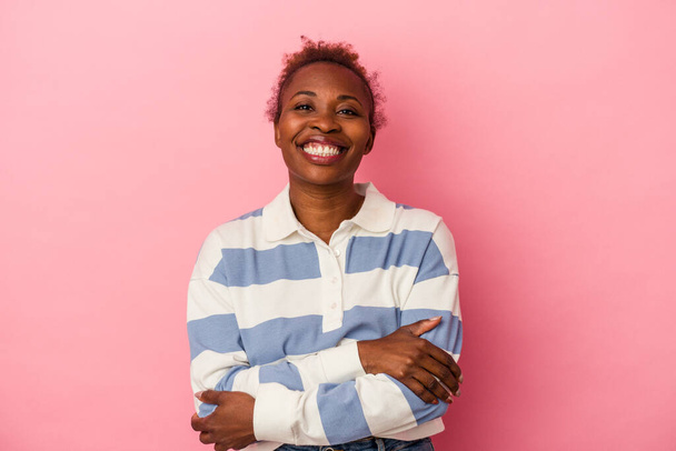 Junge afrikanisch-amerikanische Frau isoliert auf rosa Hintergrund, die sich selbstbewusst fühlt und entschlossen die Arme kreuzt. - Foto, Bild