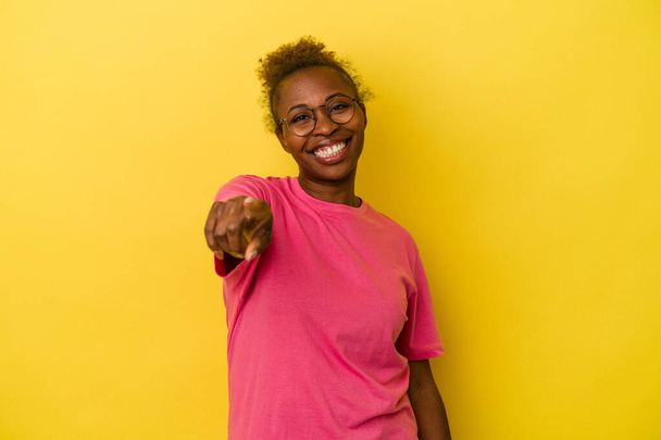 Νεαρή Αφροαμερικανή γυναίκα απομονωμένη σε κίτρινο φόντο που δείχνει προς τα εμπρός με δάχτυλα. - Φωτογραφία, εικόνα