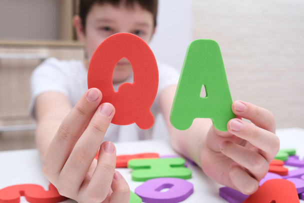 A boy holding colorful letters Q and A, questions and answers concept, solvation kids problems. - Fotoğraf, Görsel