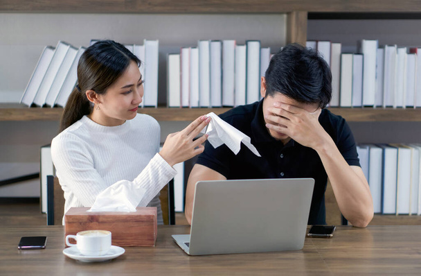Las parejas asiáticas pasan tiempo juntas en la biblioteca. Una novia ofreció un pañuelo a un hombre triste que está sufriendo de un proyecto de tesis que está haciendo. - Foto, imagen