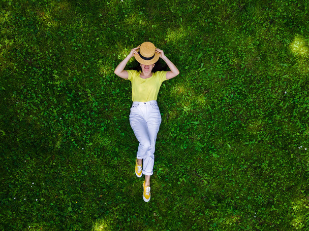 overhead view of woman laying down on green grass summertime - Foto, immagini