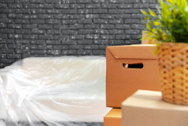 Moving in or moving out concept. Stack of boxes and packed furniture - Фото, изображение