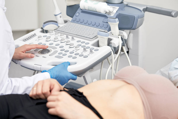Młoda kobieta poddana badaniu ultrasonograficznemu w nowoczesnej klinice - Zdjęcie, obraz