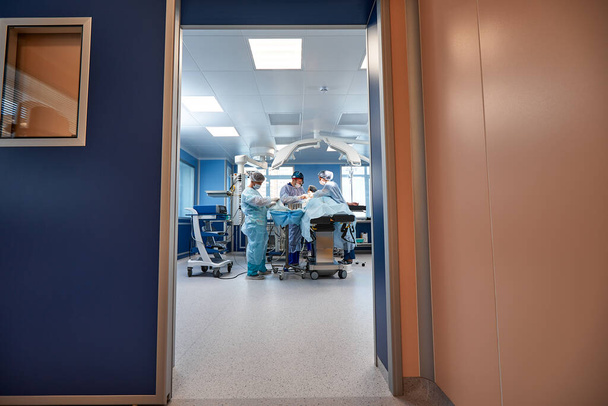 Za drzwiami sali operacyjnej, urządzenia i urządzenia medyczne w nowoczesnej sali operacyjnej. - Zdjęcie, obraz