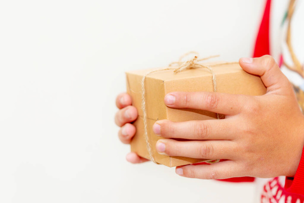 Jovem rapaz mãos em pulôver segurando caixa de presente de Natal no fundo cinzento.Natal e Ano Novo banner.Copy espaço. - Foto, Imagem