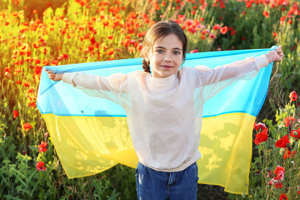 Κοριτσάκι με ουκρανική σημαία στο χωράφι με τις παπαρούνες - Φωτογραφία, εικόνα