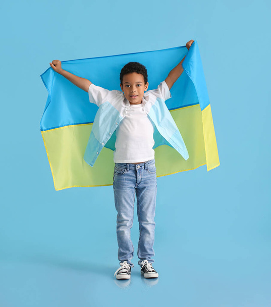 Afrikaanse jongen met Oekraïense vlag op kleur achtergrond - Foto, afbeelding