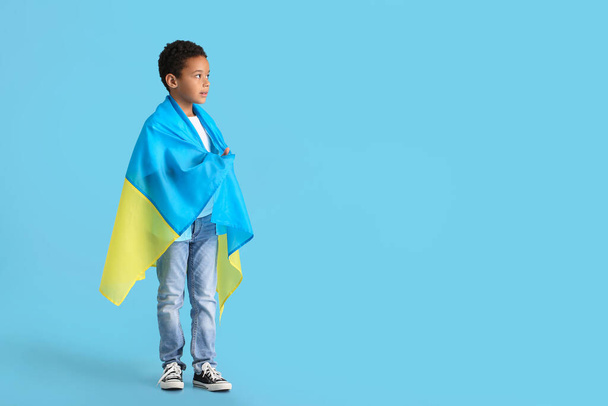 African boy with Ukrainian flag on color background - Photo, Image