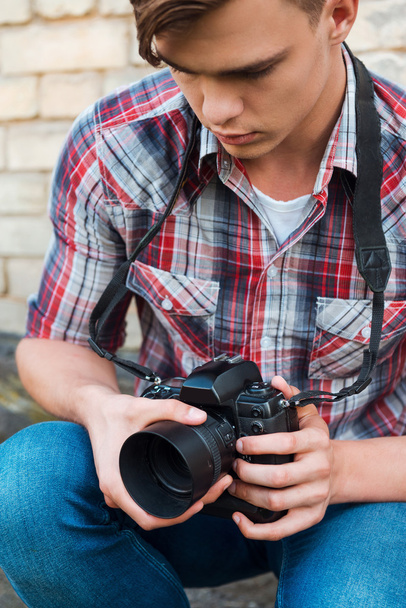 Photographer examining camera. - Fotó, kép