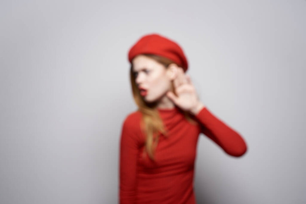 gyönyörű nő egy piros pulóver kozmetikai érzelem fény háttér - Fotó, kép
