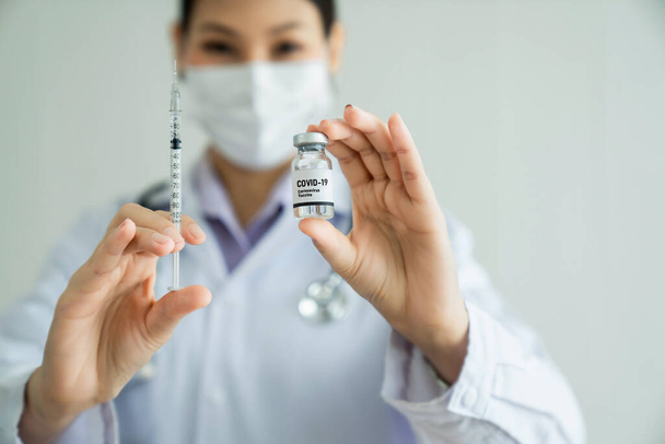 Taitava lääkäri valmistaa rokotteen taidokkaasti ennen injektiota - Valokuva, kuva
