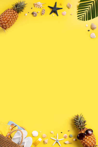 Summer fruit background design concept. Top view of holiday travel beach with shells, pineapple and palm leaves on yellow background. - Foto, afbeelding