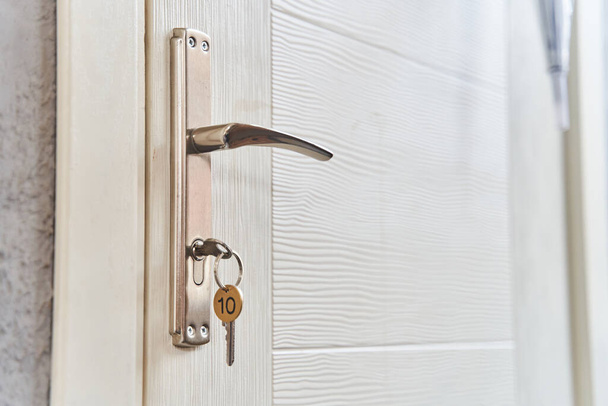 Kulcs egy kulccsal az ajtó kulcslyukában. Vegyél egy új otthon koncepciót. Ingatlanpiac. - Fotó, kép