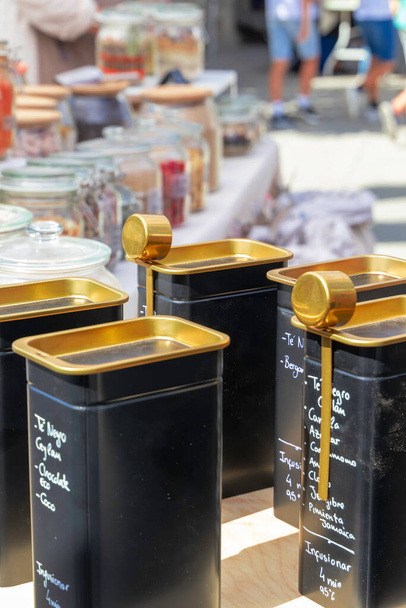 black containers with gold-plated lids full of herbal tea mix - Photo, Image