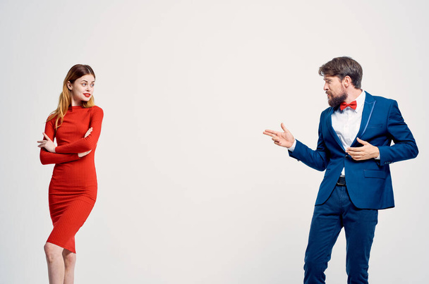 ένας άντρας με κοστούμι δίπλα σε μια γυναίκα με κόκκινο φόρεμα επικοινωνιακή μόδα απομονωμένο φόντο - Φωτογραφία, εικόνα