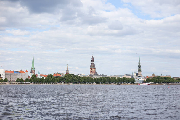 Vista cityscape de edifícios antigos da arquitetura de Riga e igrejas perto do rio Daugava. Foto tirada em um dia quente de verão nublado. - Foto, Imagem