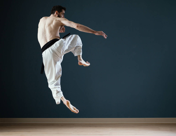 A Sensei karateka instructor trains alone in his dojo - 写真・画像