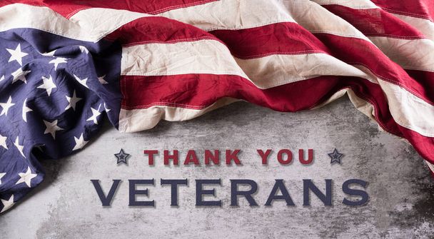 Happy Veterans Day Konzept. Amerikanische Flaggen vor dunklem Steinhintergrund. 11. November. - Foto, Bild