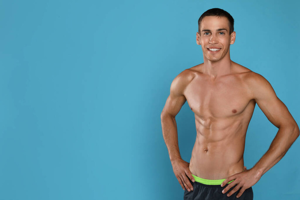 Handsome shirtless man with slim body on light blue background. Space for text - Zdjęcie, obraz