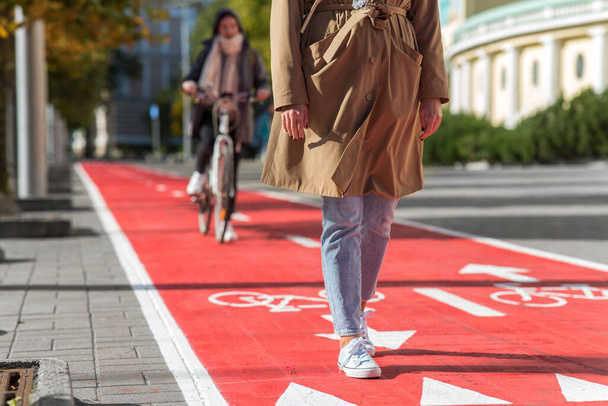 woman walking along bike lane or road for bicycles - 写真・画像