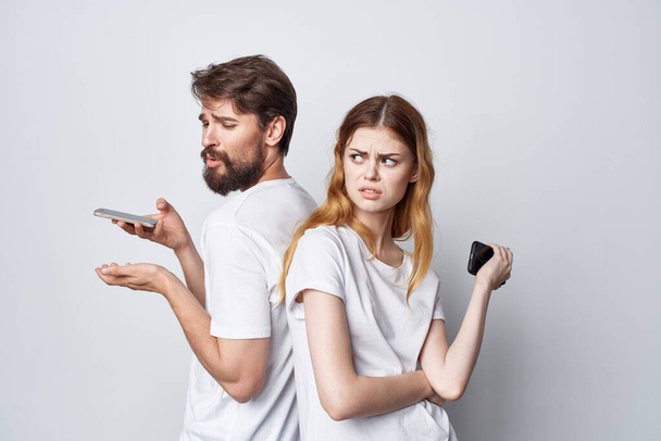 чоловік і жінка сім'я з телефонами в руці спілкування студійний спосіб життя
 - Фото, зображення