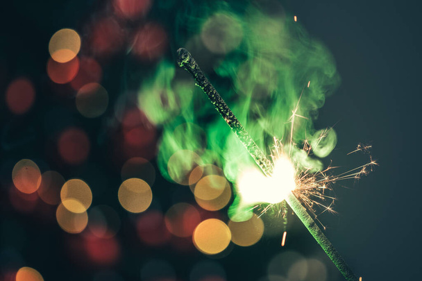 Close-up of green holiday sparkler in the dark - Foto, Bild