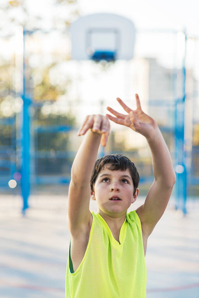 A Teenage playing basketball on an outdoors court - Photo, image