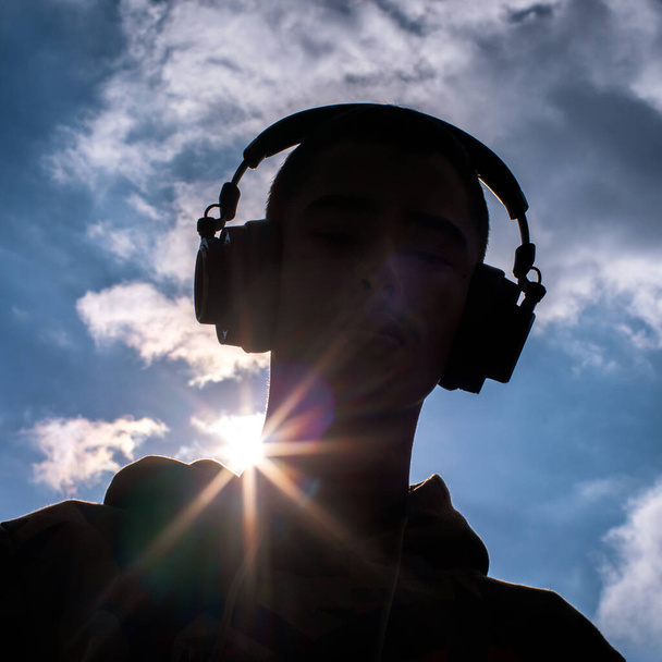 Wireless headphones on head of person. Black silhouette. - Photo, Image