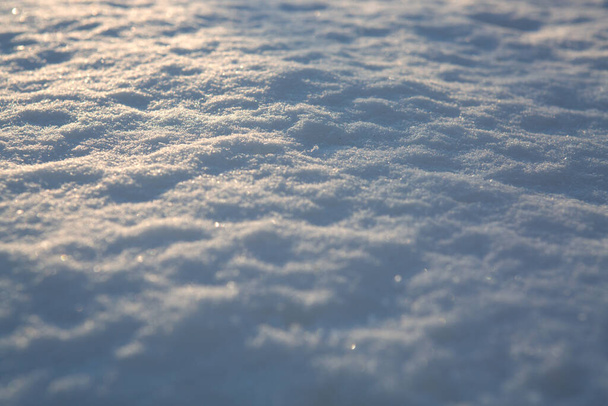 Fresh snow texture background in blue tone and sunlight. - Photo, Image