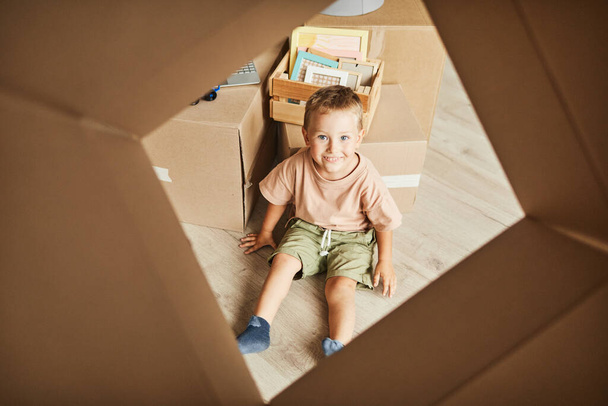 Lindo niño jugando con caja en nuevo hogar - Foto, Imagen