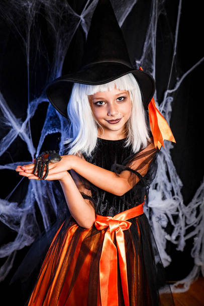 Little girl in witch Halloween costume having fun . Little witch - Fotó, kép