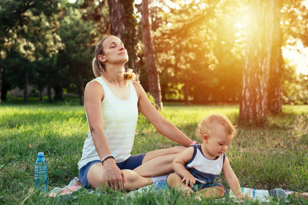 mãe com seu bebê menino fazer exercícios de ioga ao ar livre no parque - Foto, Imagem