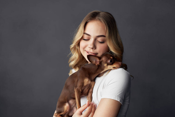 pretty woman with a small dog makeup posing dark background - Foto, Imagen
