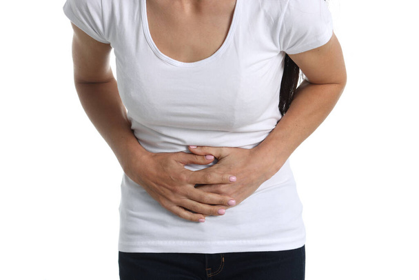 Žena s bolestí břicha v bílém tričku a bílém pozadí - Fotografie, Obrázek