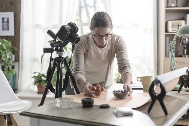 Young female photographer preparing food for a shooting, she is working at home - Foto, Imagen