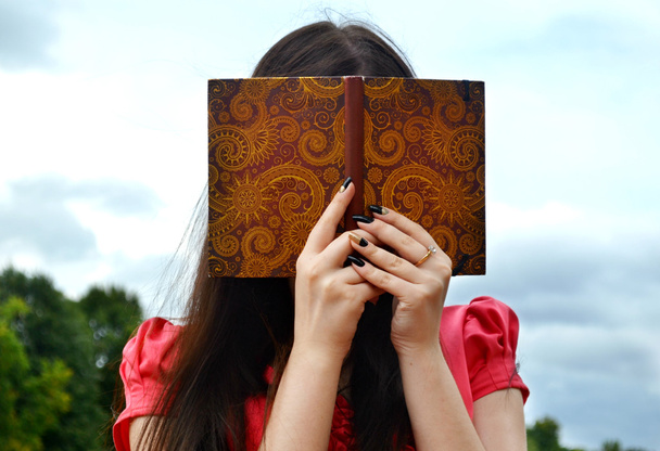Ujo brunette nainen piilossa takana muistikirja
 - Valokuva, kuva
