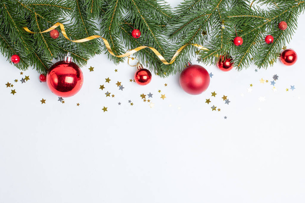 Composición de Navidad, un marco de ramas de árbol de Navidad y juguetes de árbol de Navidad sobre un fondo blanco está aislado - Foto, Imagen