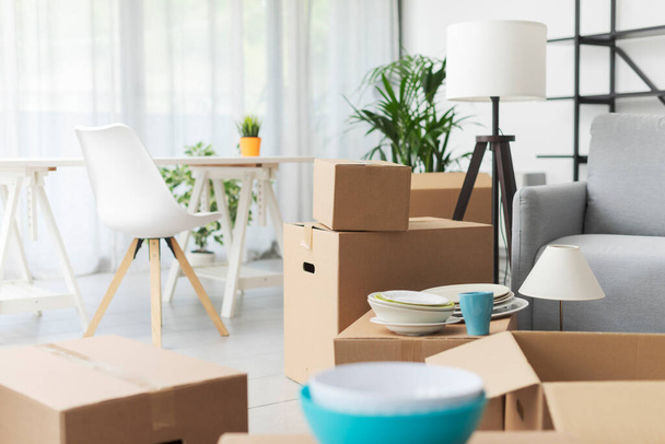 Home relocation and real estate: cardboard boxes and furniture in the new apartment - Φωτογραφία, εικόνα