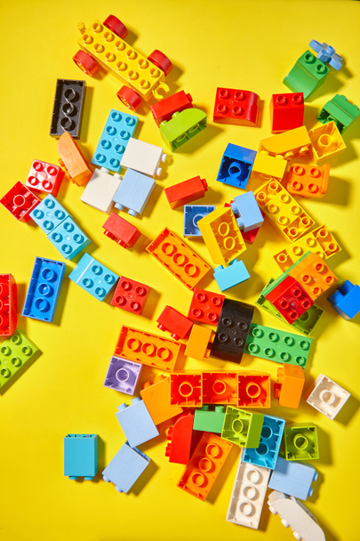 Barevné hračky cihly s Toy barevné písmena na žlutém pozadí. Vzdělávací hračka pro děti. - Fotografie, Obrázek