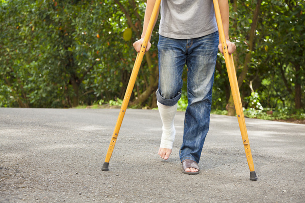 closeup of  leg on bandage with crutches  - Photo, Image