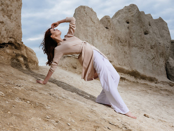 vrouw zitten op het zand elegante stijl - Foto, afbeelding