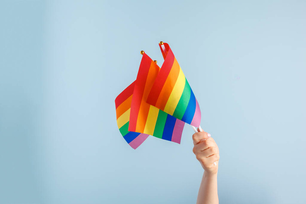 Gay flags in womens hand on grey background - Fotografie, Obrázek