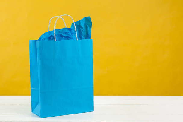 Paper shopping bags on bright yellow background - Φωτογραφία, εικόνα
